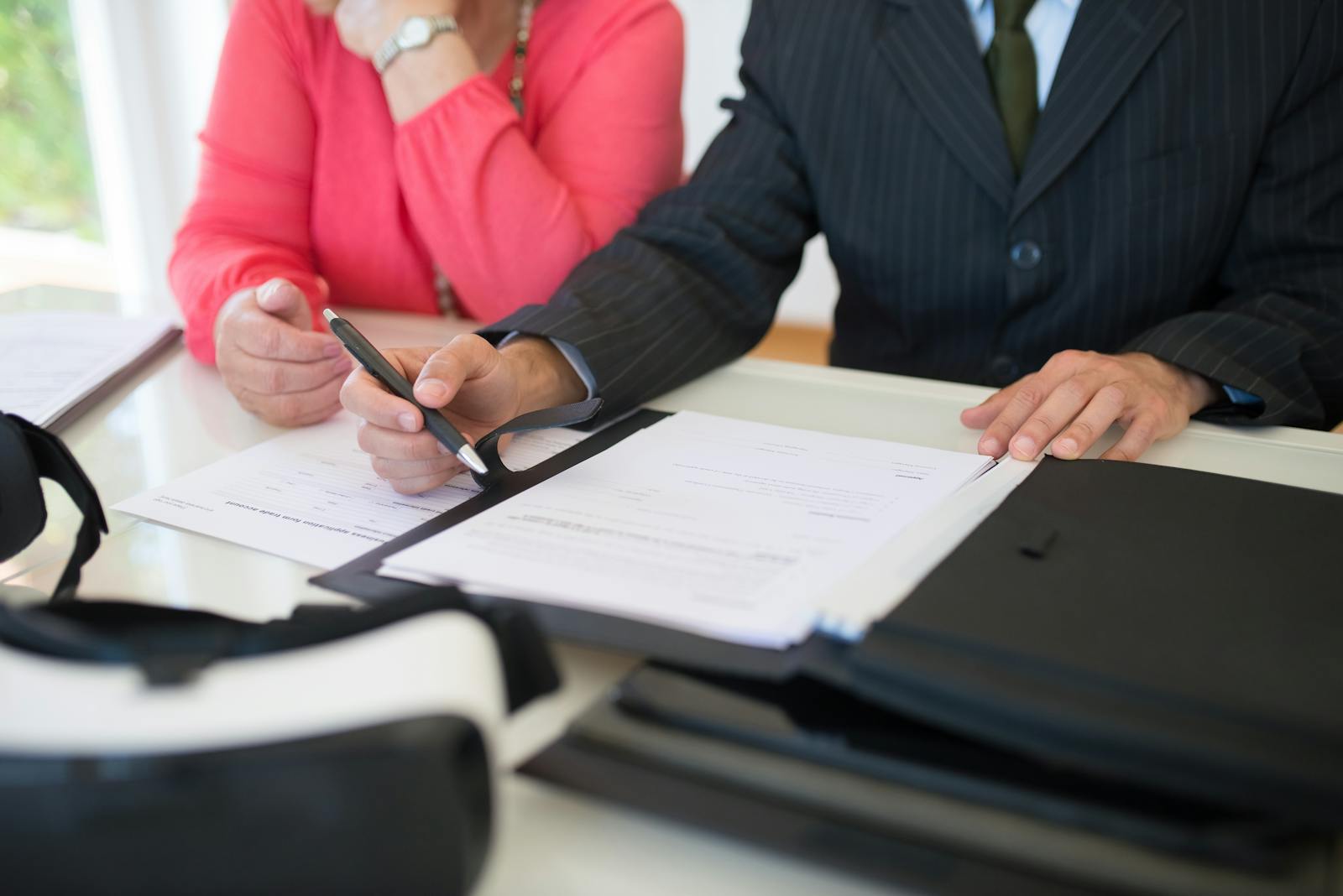 Close-up of professionals signing a business contract indoors, emphasizing agreement and documentation.