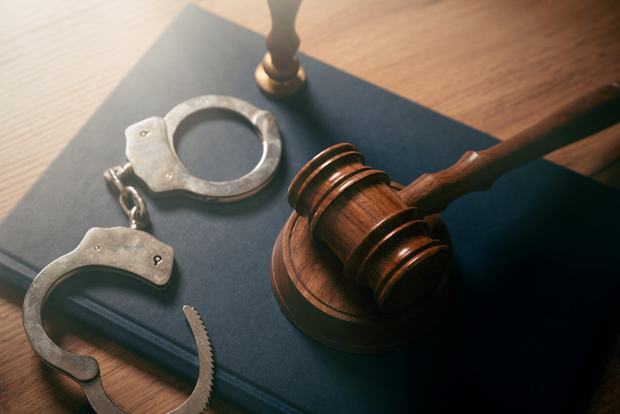 Handcuffs and wooden gavel.